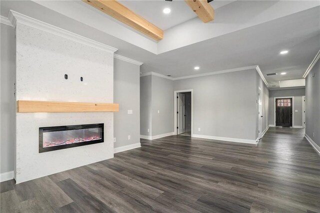 unfurnished living room featuring crown molding, a large fireplace, beamed ceiling, and dark wood-type flooring