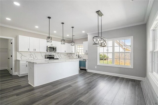 kitchen featuring dark hardwood / wood-style flooring, stainless steel appliances, white cabinets, a kitchen island, and hanging light fixtures