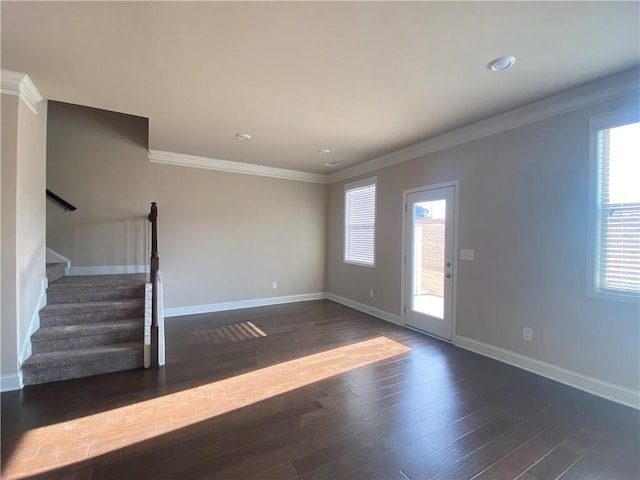 unfurnished living room with dark hardwood / wood-style flooring, crown molding, and a wealth of natural light