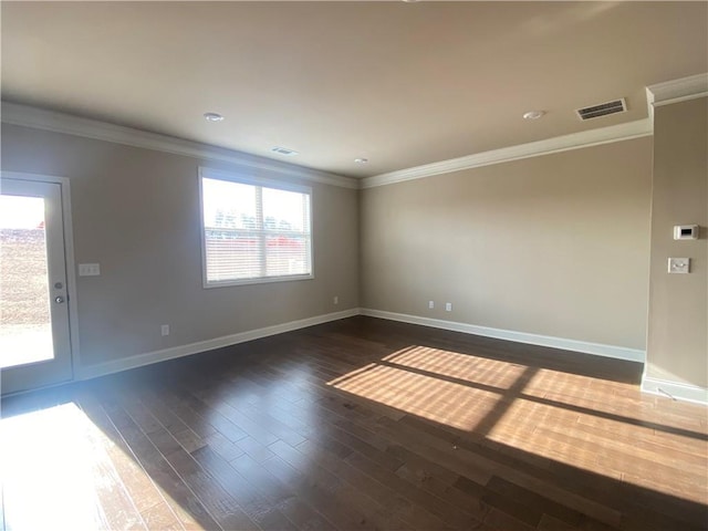 spare room featuring ornamental molding and dark hardwood / wood-style floors