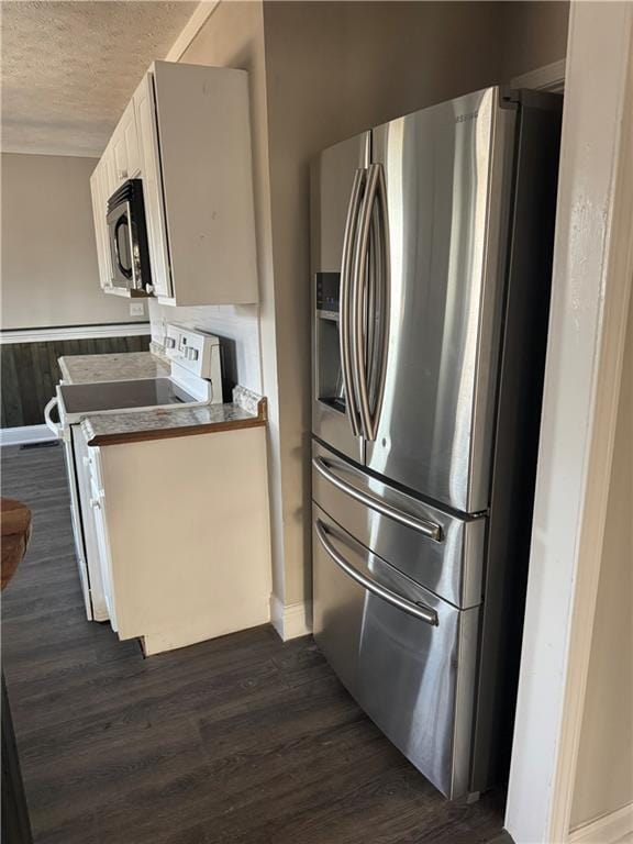 kitchen with electric stove, stainless steel fridge, white cabinetry, a textured ceiling, and dark hardwood / wood-style flooring