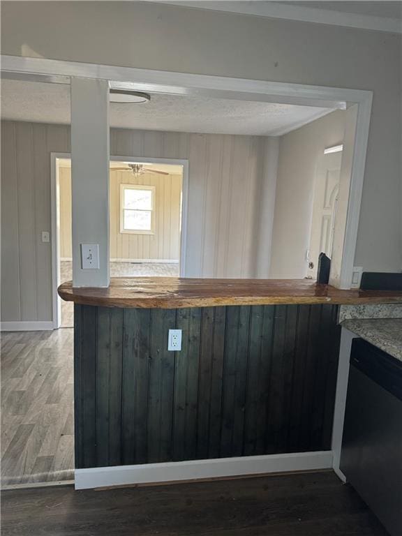 bar featuring butcher block counters, dark hardwood / wood-style floors, and dishwasher