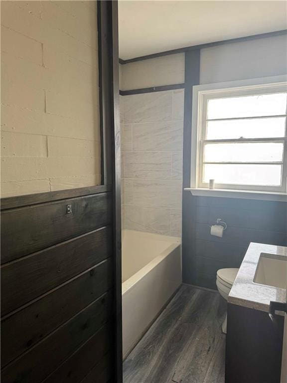 bathroom featuring a bathing tub, hardwood / wood-style floors, vanity, and toilet