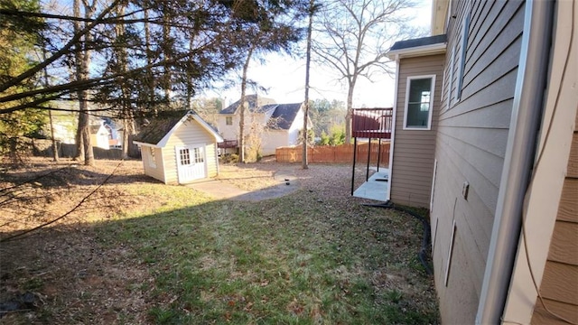 view of yard featuring a storage shed, a deck, an outdoor structure, and a fenced backyard