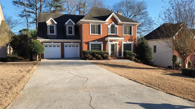 colonial home with concrete driveway, brick siding, a chimney, and an attached garage