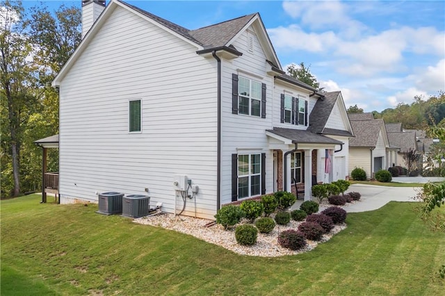 view of side of property featuring a yard and central AC unit