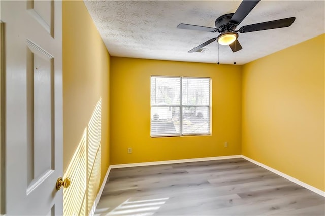 empty room with a textured ceiling, hardwood / wood-style floors, and ceiling fan