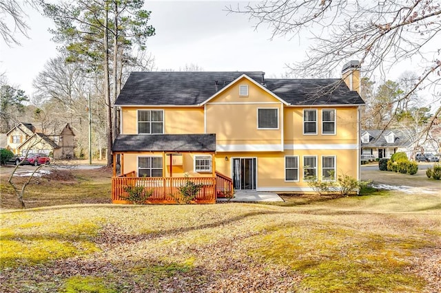 view of front of house featuring a deck, a front lawn, and a patio