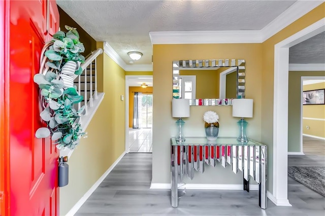 entrance foyer with a textured ceiling, hardwood / wood-style floors, and ornamental molding