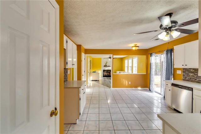 kitchen featuring white cabinets, decorative backsplash, ceiling fan, and dishwasher