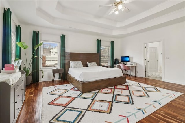 bedroom with ceiling fan, crown molding, hardwood / wood-style flooring, and a raised ceiling