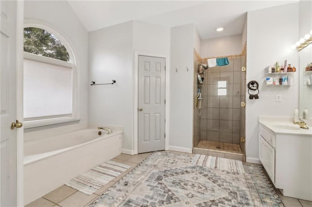 bathroom featuring vanity, plus walk in shower, and tile patterned flooring