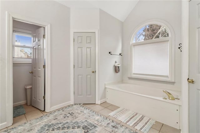 bathroom with a wealth of natural light, tile patterned floors, and lofted ceiling