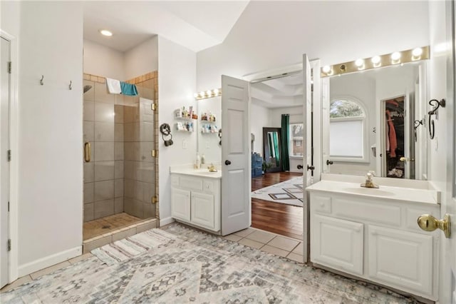 bathroom with a shower with shower door, tile patterned floors, and vanity