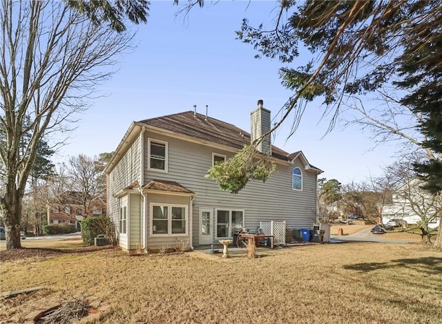 rear view of house featuring a yard and a patio