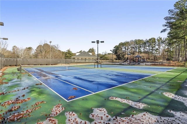 view of tennis court with a playground