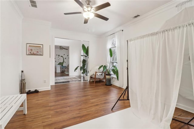 entrance foyer with ceiling fan, dark hardwood / wood-style flooring, and ornamental molding