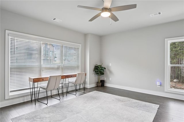 interior space featuring wood finished floors, baseboards, visible vents, and ceiling fan