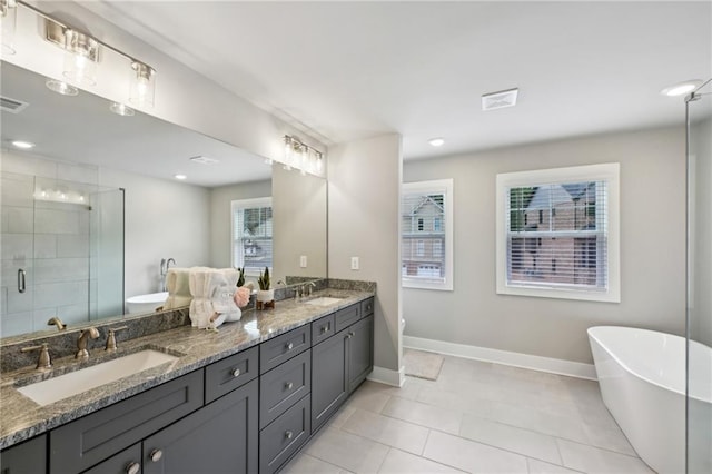 bathroom with a sink, a freestanding bath, double vanity, and a shower stall