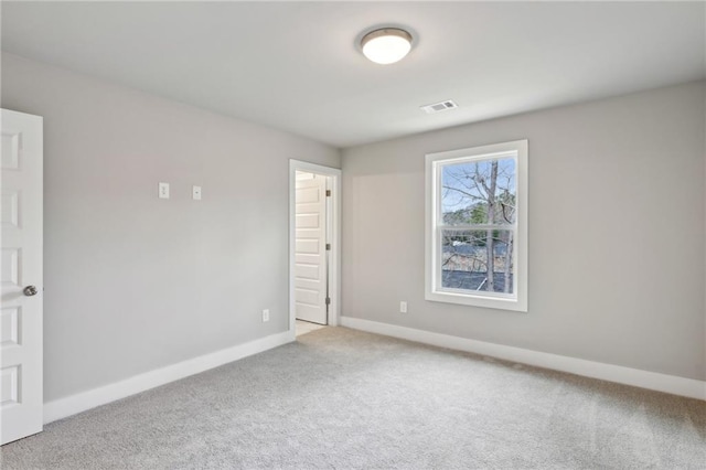 carpeted spare room with baseboards and visible vents