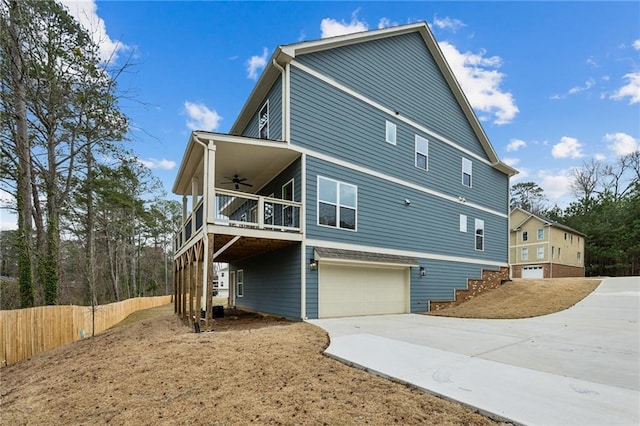 exterior space with driveway, fence, stairway, a garage, and ceiling fan