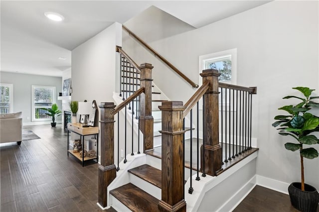 staircase featuring baseboards and wood finished floors