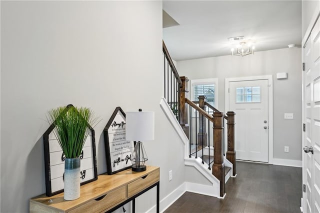 foyer entrance featuring stairway, baseboards, an inviting chandelier, and dark wood-style flooring