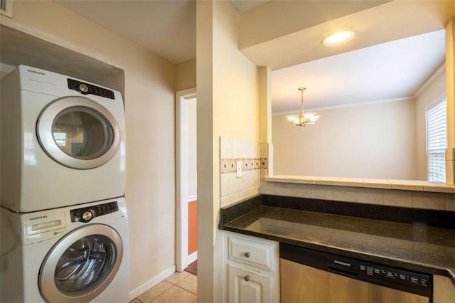 177 NW Amherst Pl, Atlanta, GA 30327 - laundry room featuring light tile patterned flooring, stacked washer / dryer, a chandelier, baseboards, and laundry area