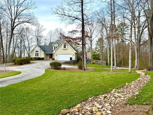 view of front of house featuring driveway, a garage, fence, a front lawn, and stucco siding