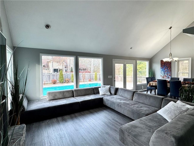 living area with lofted ceiling, a notable chandelier, and wood finished floors