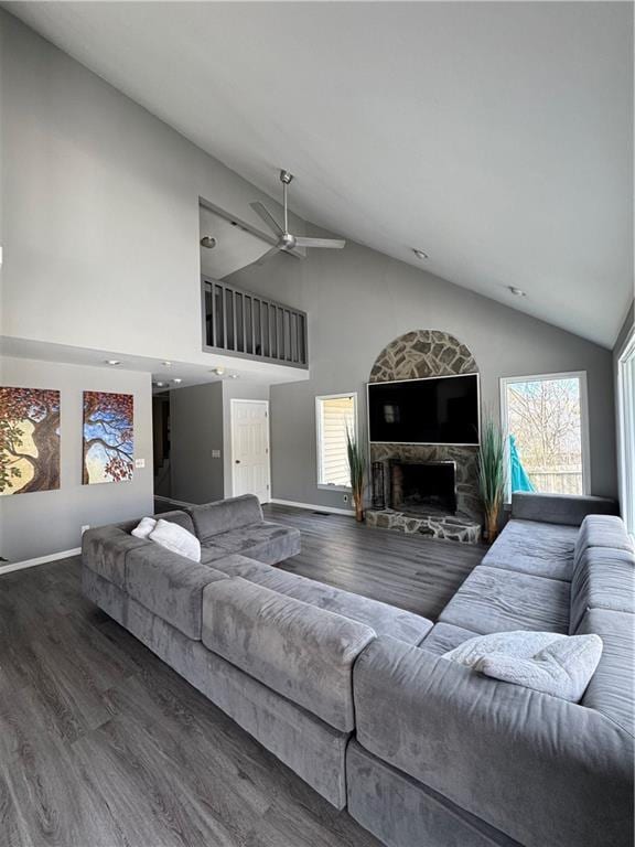 living area with high vaulted ceiling, a ceiling fan, baseboards, and wood finished floors