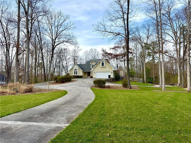 view of front of home with a garage, fence, driveway, and a front lawn