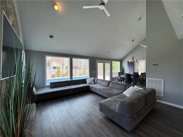 living area with dark wood finished floors, visible vents, high vaulted ceiling, baseboards, and ceiling fan with notable chandelier