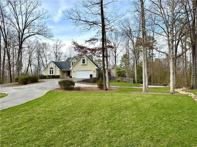 view of front of home featuring an attached garage, fence, driveway, stucco siding, and a front lawn