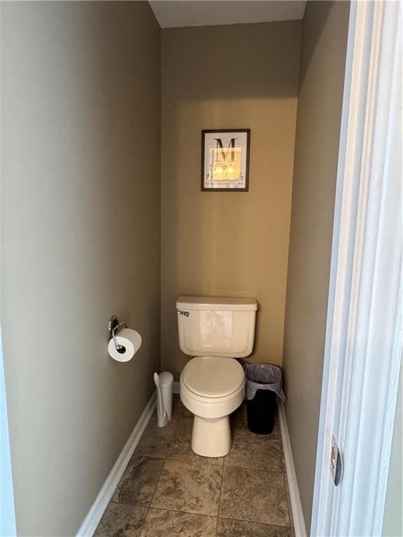 bathroom featuring toilet and baseboards