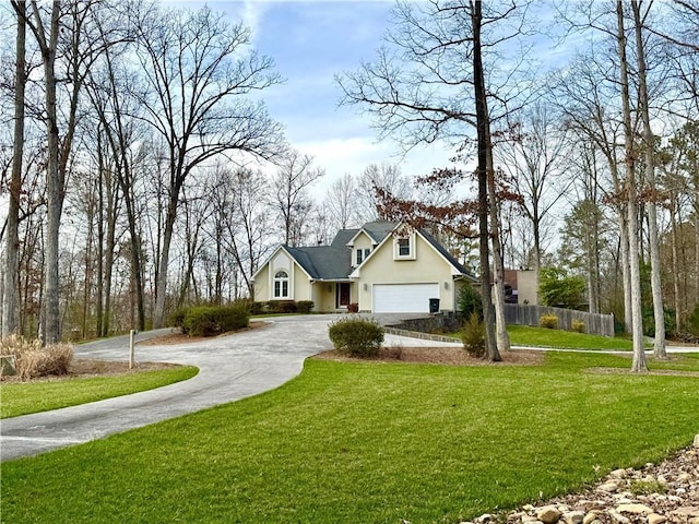 traditional-style house with stucco siding, a front yard, fence, a garage, and driveway