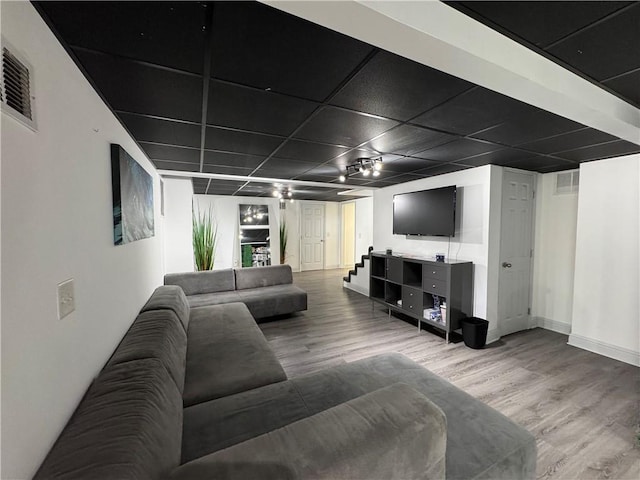 living room with wood finished floors, visible vents, and baseboards