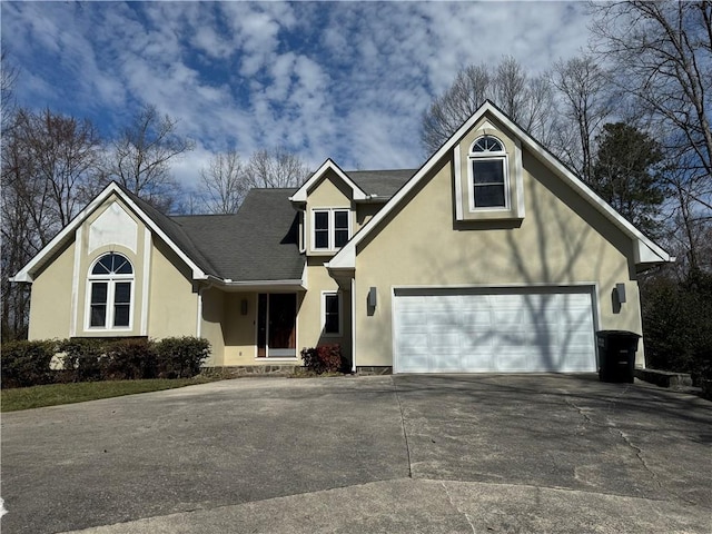 view of front of home featuring driveway, roof with shingles, a garage, and stucco siding