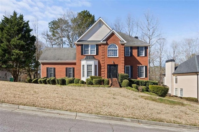 colonial inspired home with brick siding