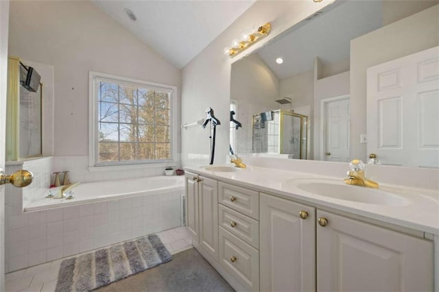 bathroom with vaulted ceiling, a garden tub, a sink, and a shower stall