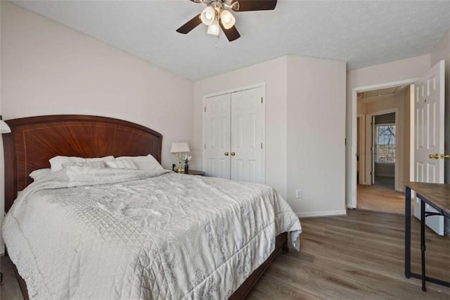 bedroom featuring attic access, baseboards, a ceiling fan, wood finished floors, and a closet