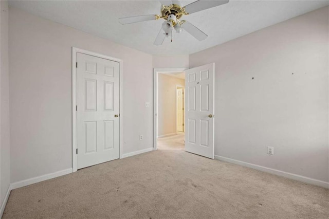 unfurnished bedroom featuring ceiling fan, carpet, and baseboards