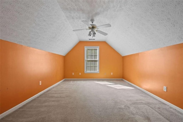 bonus room featuring carpet floors, baseboards, vaulted ceiling, and a textured ceiling