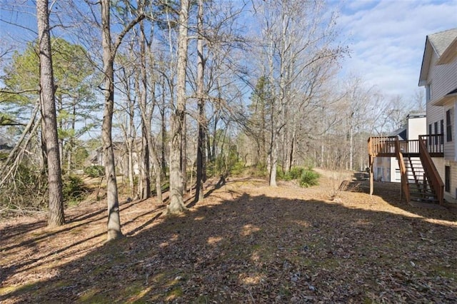 view of yard featuring stairway and a deck