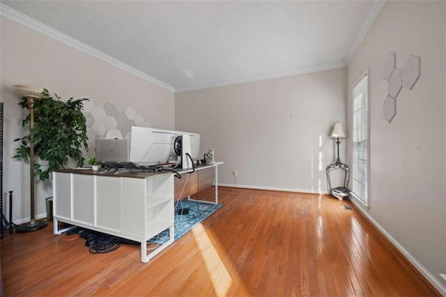 home office featuring baseboards, hardwood / wood-style flooring, and crown molding