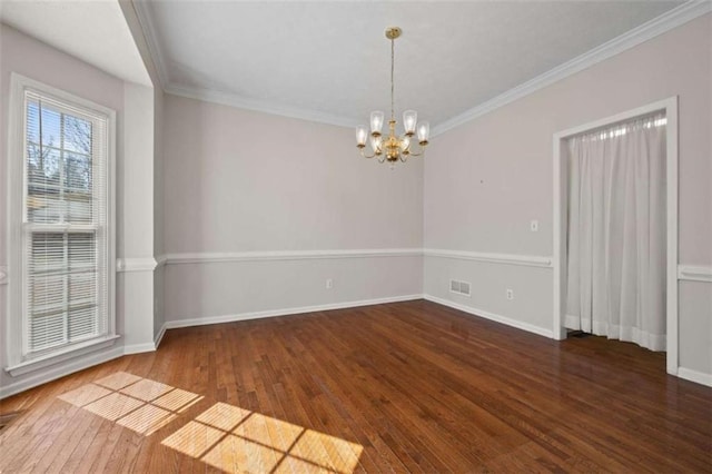 unfurnished room with crown molding, a notable chandelier, baseboards, and wood finished floors