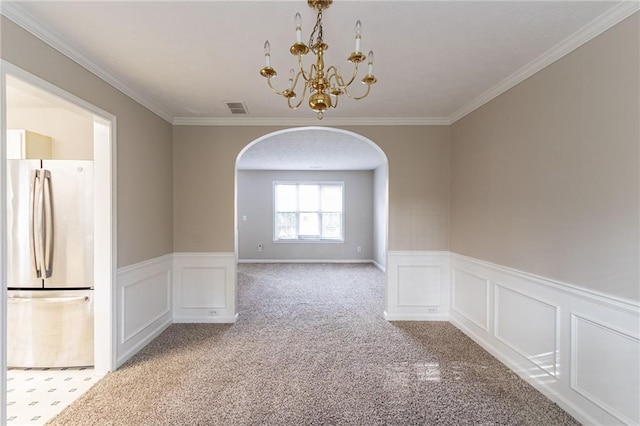 unfurnished dining area featuring light colored carpet, ornamental molding, and an inviting chandelier