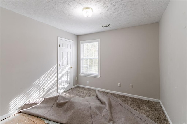 unfurnished bedroom with carpet flooring and a textured ceiling