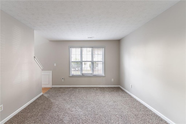 carpeted spare room featuring a textured ceiling