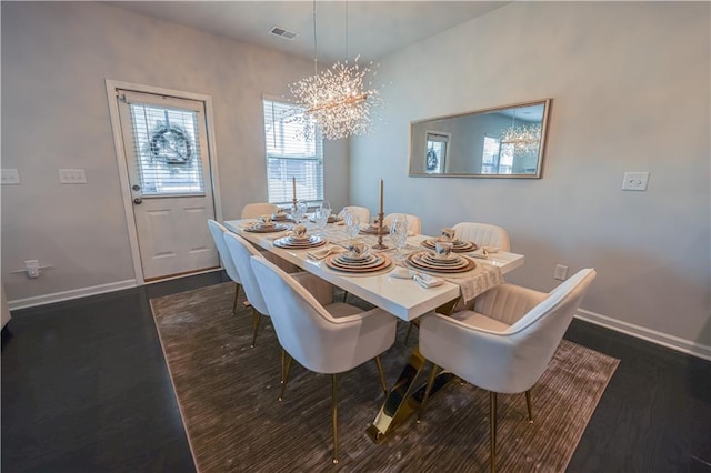 dining room featuring dark wood-type flooring and an inviting chandelier